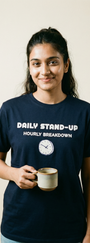 Person wearing a navy blue t-shirt with text and holding a mug against a plain background